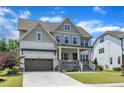 Beautifully designed home with a covered porch, an attached garage, and a lush, green lawn at 1716 Aberdour Dr, Apex, NC 27502
