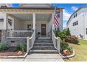 Inviting front porch with stone stairs, white railings, and a stained wood front door at 1716 Aberdour Dr, Apex, NC 27502
