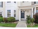 Charming townhouse entrance with a dark door, manicured landscaping, and well-lit porch at 1966 Grassy Banks Dr, Raleigh, NC 27610