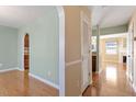 Well-lit hallway featuring hardwood floors, an arched doorway, and neutral paint at 1966 Grassy Banks Dr, Raleigh, NC 27610
