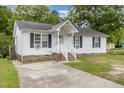 Inviting single-story home featuring a cozy front porch and a well-maintained lawn at 205 Person St, Oxford, NC 27565