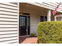 Covered entrance featuring a decorative glass front door, brick pavers, and an American flag at 215 Dungarven Loop, Cary, NC 27513