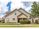 Beige two-story home showcasing a well-manicured lawn and tidy landscaping at 215 Dungarven Loop, Cary, NC 27513