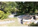 Outdoor patio area surrounded by lush greenery with a scenic lake view at 227 Shalimar Dr, Durham, NC 27713