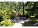 Outdoor patio area surrounded by lush greenery and a scenic lake view at 227 Shalimar Dr, Durham, NC 27713