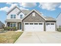 This is a two story home featuring a long driveway and a stone accentuated two car garage at 254 Arlie Ln, Lillington, NC 27546