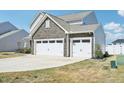 Home featuring two white garages doors accented by stone finish at 254 Arlie Ln, Lillington, NC 27546