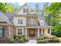 Attractive exterior with a stone facade, shingle accents, and a cozy, covered front porch at 286 Harrison Pond Dr, Pittsboro, NC 27312