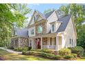 Beautiful home showcasing a stone and siding exterior, complemented by lush landscaping at 286 Harrison Pond Dr, Pittsboro, NC 27312