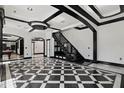 Open-concept living area with grand black and white floors, custom staircase, and recessed lighting at 318 W Lillington St, Angier, NC 27501