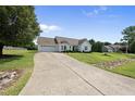 View of the exterior showcasing a lengthy driveway, landscaped yard, and a well-maintained white house at 3705 Highland Creek Dr, Apex, NC 27539