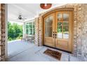 Charming arched double front doors with brick accents and view of the inviting porch at 386 Monteith Dr, Chapel Hill, NC 27516