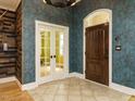 Inviting foyer featuring decorative doors, textured wallpaper, and tile flooring at 410 Mountain Laurel, Chapel Hill, NC 27517