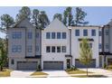 View of the front exterior of the home showing the garage doors and modern architectural style at 4502 Mint Leaf Lane Ln, Raleigh, NC 27612