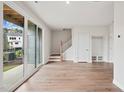 Modern living area with hardwood floors, sliding glass doors, and a staircase at 4502 Mint Leaf Lane Ln, Raleigh, NC 27612