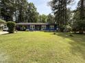 Charming single-story home with a lush green lawn, mature trees, and attached carport at 509 Forest Ridge Rd, Garner, NC 27529