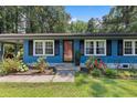 Close-up of the front of a blue home with black shutters and a red door at 509 Forest Ridge Rd, Garner, NC 27529