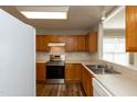 Bright kitchen features stainless steel appliances, wood cabinets, and a window to the dining area at 518 S Coalport Dr, Apex, NC 27502