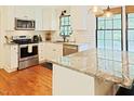 Modern kitchen featuring stainless steel appliances, granite countertops, and white cabinetry at 5304 Cypress Ln, Raleigh, NC 27609