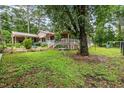 Spacious backyard with a charming patio, fenced garden area, and mature trees at 608 20Th St, Butner, NC 27509