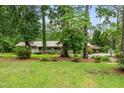 Single-story house with a metal roof, covered porch, mature trees, and detached carport at 608 20Th St, Butner, NC 27509