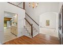 Open entryway with staircase, chandelier, hardwood flooring and an arched doorway at 6321 Malvern Ln, Hillsborough, NC 27278