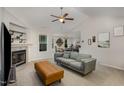 Cozy living room featuring a fireplace, neutral-toned sofa, and a glimpse into the dining area at 65 Cattail Ln, Zebulon, NC 27597