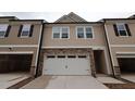 New two-story townhouse with neutral siding, stone accents, attached two-car garage and driveway at 6973 Doddridge Ln # 17, Cary, NC 27519