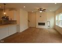 Open-concept living room with fireplace, ceiling fan, and large windows for ample natural light at 6973 Doddridge Ln # 17, Cary, NC 27519