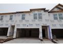View of new construction townhomes featuring a garage and large windows at 7102 Hubner Pl # 46, Cary, NC 27519
