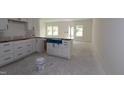 Bright, spacious kitchen with white cabinets, an island, and modern design features at 7102 Hubner Pl # 46, Cary, NC 27519
