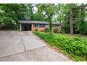 Traditional brick home featuring a carport, surrounded by lush greenery and a long driveway at 720 Sherrybrook Dr, Raleigh, NC 27610
