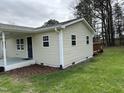This is a single story home that features clean siding, mulch beds, and a covered front porch at 726 Thompson St, Pittsboro, NC 27312