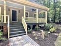 Inviting covered front porch with painted railing and brick paver walkway at 8116 Reynard Rd, Chapel Hill, NC 27516