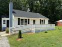 Cozy home displaying a freshly stained deck and chimney at 902 Roanoke Ave, Henderson, NC 27536