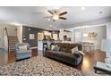 Open concept living room featuring hardwood floors, modern furniture, a ceiling fan and lots of natural light at 108 White Burley Ct, Durham, NC 27703