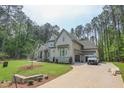 The exterior of the house shows the driveway and the lush tree coverage along the exterior of the lot at 1212 Perry Bluff Dr, Wake Forest, NC 27587