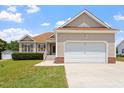 View of the attractive home featuring a two-car garage, manicured front lawn and mature landscaping at 1325 Sweetclover Dr, Wake Forest, NC 27587