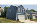Side view of a two-story home with blue siding and a white garage door at 134 N Keatts Winner Ct, Wilson's Mills, NC 27520