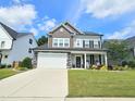 Charming two-story home featuring a well-manicured lawn and a stone-accented facade with a two-car garage at 1412 Queen Trigger Dr, Fuquay Varina, NC 27526