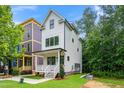 Beautiful two-story home with a welcoming front porch, black trim windows, and lush green lawn at 1621 Ella Wiggins Way, Raleigh, NC 27603