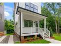 Inviting front porch featuring classic white railings, wooden steps, and a view of the manicured lawn at 1621 Ella Wiggins Way, Raleigh, NC 27603