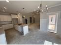 Bright, open kitchen with island, white cabinets, and stainless steel appliances at 165 Tee Dr, Selma, NC 27576