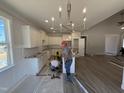 Modern kitchen with white cabinets, granite countertops, stainless steel appliances, pendant lighting, and an open concept layout at 165 Tee Dr, Selma, NC 27576