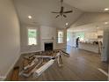 Spacious living room showcasing light wood flooring, a cozy fireplace, ceiling fan, and an abundance of natural light at 165 Tee Dr, Selma, NC 27576