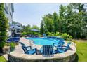 Relaxing backyard pool area with lounge chairs and lush landscaping, perfect for outdoor enjoyment at 205 Silent Cove Ln, Holly Springs, NC 27540