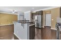 A kitchen showcases dark wood floors, granite countertops, stainless steel appliances, and bar seating at 211 Westgrove Ct, Durham, NC 27703