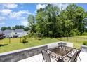Backyard stone patio with a glass table and seating at 2128 Jollay St, Durham, NC 27703