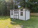 The large storage shed offers ample space and features a white exterior with black trim at 2210 Pilot-Riley Rd, Zebulon, NC 27597