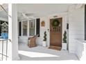 Inviting front porch with swing, white pillars, and door with wreath at 2225 Creston Rd, Raleigh, NC 27608